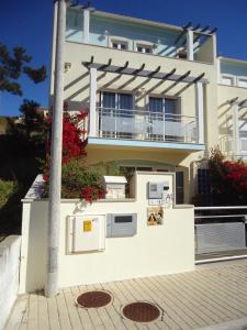 een wit huis met een balkon en een paal bij Casa Senhor dos Passos in Nazaré