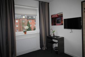 a room with a window with a television and a desk at Heimat St. Pauli in Hamburg