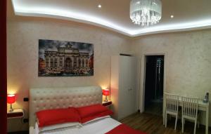 Un dormitorio con una cama con almohadas rojas y una lámpara de araña. en Luxury Rome Savini Guest House, en Roma