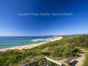 a beach with a view of the ocean at Tabourie Lake Motor Inn in Ulladulla