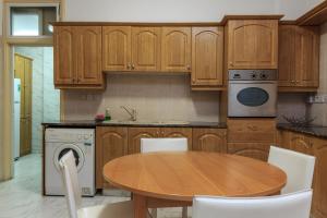 cocina con armarios de madera y mesa de madera en Les Palmiers House, en Lárnaca