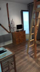 a living room with a desk with a laptop and a ladder at studio saint lary au pla d'adet in Saint-Lary-Soulan