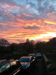 een groep auto's geparkeerd op een weg met zonsondergang bij Blue Bell Inn in Embleton