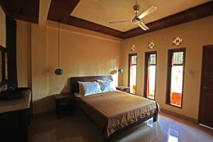 a bedroom with a bed and a ceiling fan at Arsuma Guest House in Gianyar