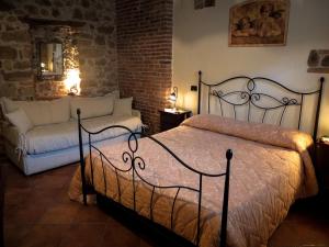 カステルブオーノにあるBaglio Bonomoのベッドルーム(ベッド1台、ソファ付)