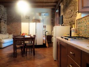 a kitchen with a table and a white refrigerator at Baglio Bonomo in Castelbuono