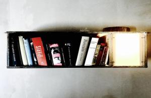 a shelf filled with books on a wall at Pippo's Little Resort in Poppi