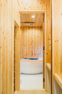 a bathroom with a tub in a wooden wall at Casa OGUMO in Kyoto +39 photos