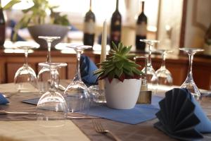 a table with wine glasses and a potted plant on it at Hotel Ristorante Ätna in Ulrichstein