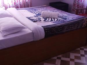 a bed with white blankets on top of it at Hotel Harmony in Pokhara