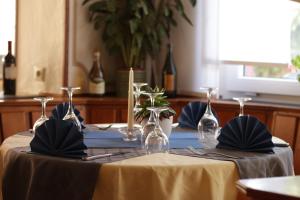 a table with a yellow table cloth and wine glasses at Hotel Ristorante Ätna in Ulrichstein