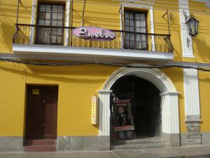 un edificio amarillo con balcón y una señal en él en Ñaupa House Hostel, en Cochabamba