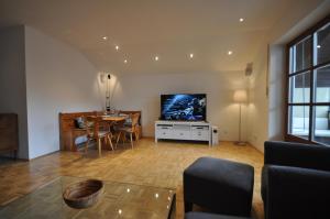 ein Wohnzimmer mit einem Tisch und einem TV in der Unterkunft Apartment am Mohrenplatz in Garmisch-Partenkirchen