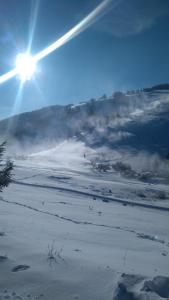 un champ enneigé avec le soleil dans le ciel dans l'établissement Chata u sovicky Malino Brdo, à Ružomberok