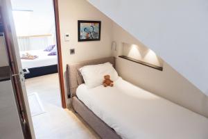 a bedroom with a bed with a teddy bear on it at Hotel Villa d'Elsa in Juan-les-Pins