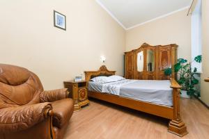 キーウにあるApartment in Kostelna srtのベッドルーム1室(ベッド1台、革張りの椅子付)