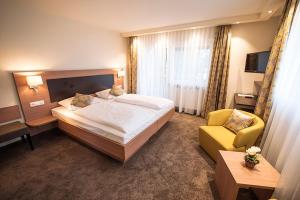 a hotel room with a bed and a yellow chair at Gasthof Pfauen in Oberkirch +14 photos