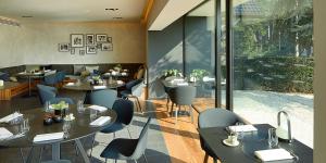 a restaurant with tables and chairs and windows at B&B Ceder10 in Kruibeke