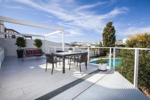 a patio with a table and chairs on a balcony at Villa Carabeo San Salvador Nerja in Nerja