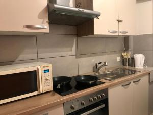 a kitchen with a microwave and a stove with pots and pans at Interlaken Marco Hostel in Interlaken