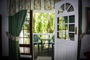 an open door to a balcony with a table and chairs at Aquaelberg Place in Swellendam