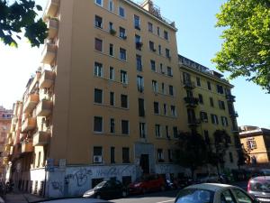 ローマにあるTiberhaus 2 la casa delle luci e delle ombreの車が目の前に停まった高い黄色の建物