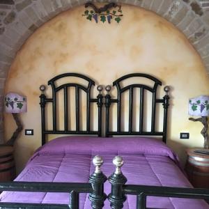 Un dormitorio con una cama negra con sábanas moradas en La Meridiana en Calitri