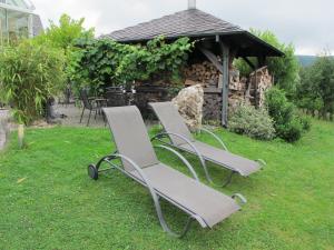 trois chaises assises dans l'herbe devant un kiosque dans l'établissement Ferienweingut Port, à Bernkastel-Kues