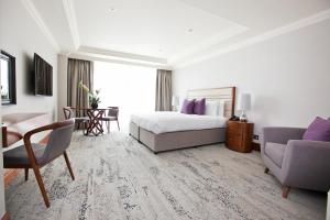 een hotelkamer met een bed, een bureau en een stoel bij Sanctum Maida Vale in Londen