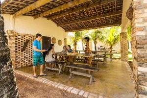 a group of people sitting at a table in a patio at Pousada Cabanas de Búzios in Nísia Floresta