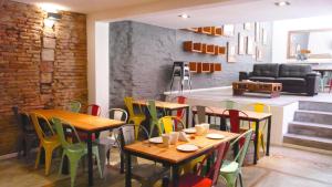 a restaurant with wooden tables and colorful chairs at Circus Hotel Montevideo in Montevideo