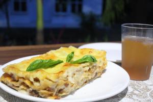 a white plate with a piece of food and a drink at Summer Homestay Bali in Nusa Dua +50 photos