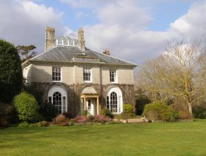 una antigua casa de piedra con un patio de césped en The Lynch Country House en Somerton