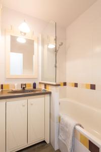 a bathroom with a sink and a bath tub at Résidence Pierre & Vacances l'Ange Gardien in Villefranche-sur-Mer