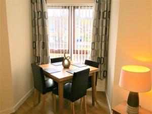 a dining room table with chairs and a window at Castle Gait, Paisley in Paisley