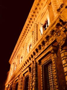 un edificio con una torre de reloj por la noche en TL Palazzo Fantuzzi, en Bolonia