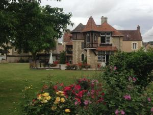 an old house with flowers in the yard at Manoir de l'Islay in Vendeuvre