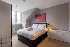 a bedroom with a bed with a teddy bear on it at ALTIDO Spacious 2BR Apt, moments from West End in Edinburgh