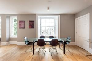 a dining room with a glass table and chairs at ALTIDO Spacious 2BR Apt, moments from West End in Edinburgh