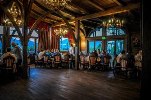 a group of people sitting at tables in a restaurant at Castel Transilvania in Baia Mare