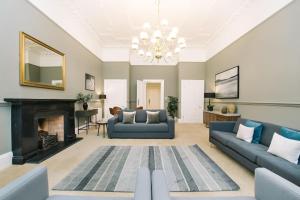 a living room with two blue couches and a fireplace at ALTIDO Palmerston Place Residence - Luxury City Centre Apt with Private Parking in Edinburgh
