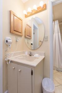 een badkamer met een wastafel en een spiegel bij Sea Club IV Resort in Daytona Beach Shores