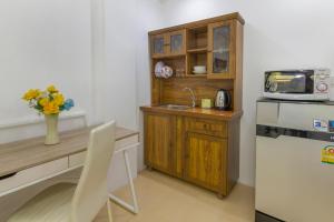 a kitchen with a desk and a sink and a refrigerator at Kontiki Guesthouse in Jomtien Beach