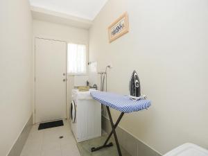 a laundry room with a table and a washing machine at All Seasons Port Elliot Holiday House in Port Elliot