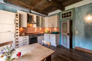 a kitchen with white cabinets and a wooden table at Kloster Malgarten in Bramsche