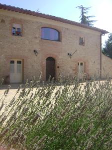 ein großes Steinhaus mit einem Zaun davor in der Unterkunft Agriturismo La Segolina in Colle di Val d’Elsa