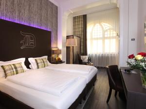 ein Schlafzimmer mit einem großen Bett und einem Schreibtisch in der Unterkunft Hotel am Markt Bacharach in Bacharach
