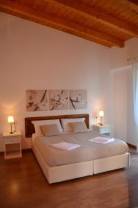 ein Schlafzimmer mit einem großen Bett mit zwei Tischen und zwei Lampen in der Unterkunft Residence i Fiori in Piantedo