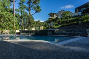 a swimming pool in front of a house at Arenal Observatory Lodge & Trails in Fortuna