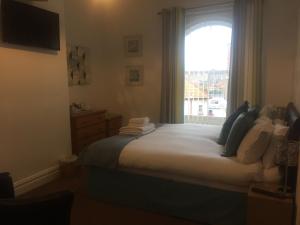 a bedroom with a large bed with a window at Seacrest Guest House Room Only in Whitby